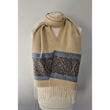 A beige scarf featuring a border of Celtic knots and a tassel trim