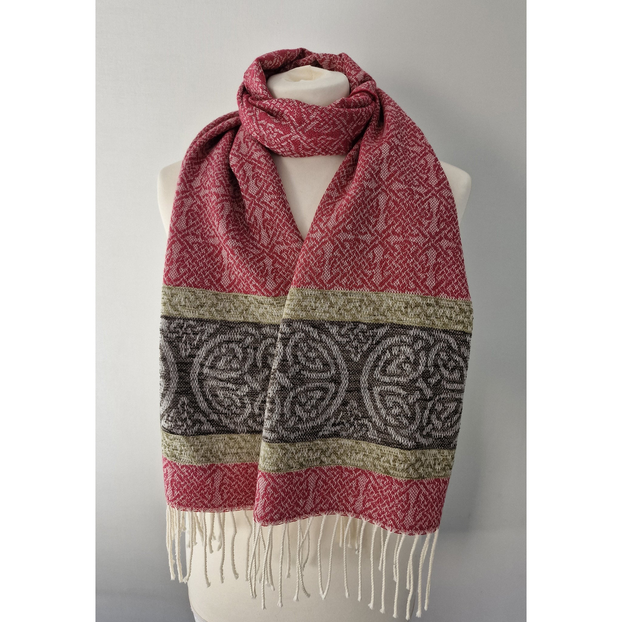A pink scarf featuring a border of Celtic knots and a tassel trim