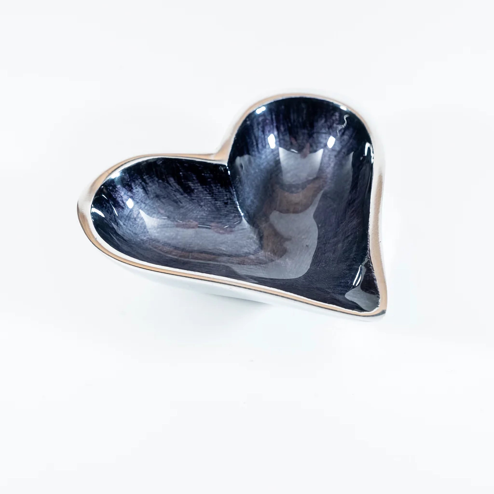 A silver aluminium heart shaped dish with black ombre enamel inside