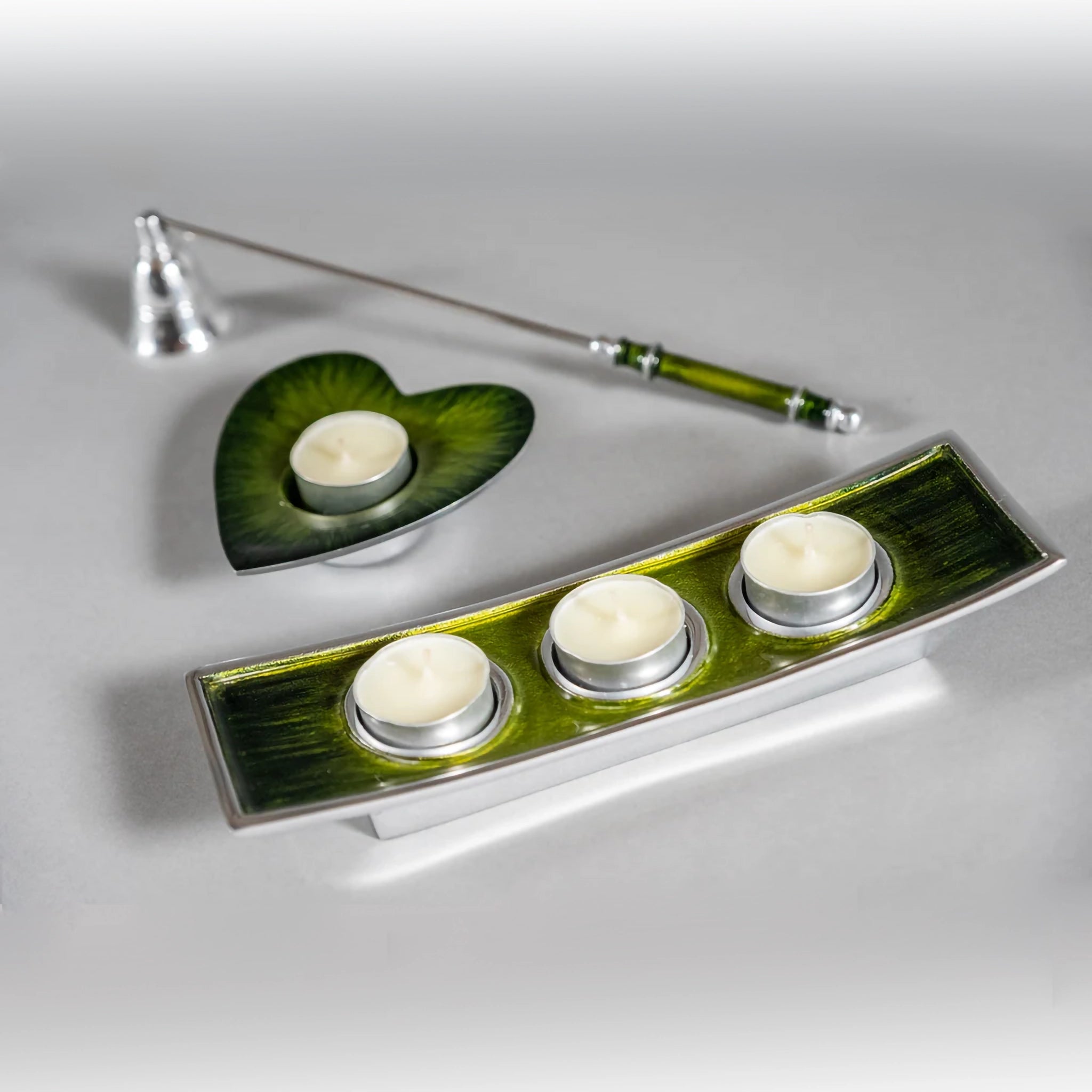 A set of green ombre enamelled candle holders and candle snuffer