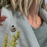 Polished silver bee brooch with black & yellow enamel on a model's scarf