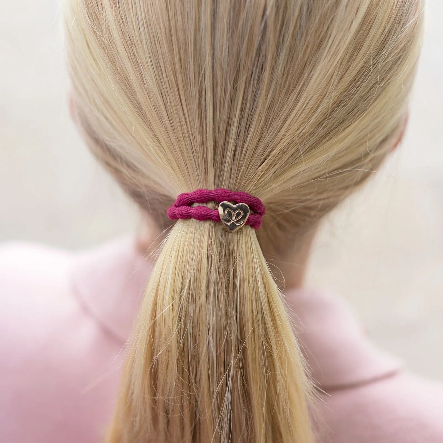 Burgundy red coloured bubble shaped hair tie with gold heart charm model