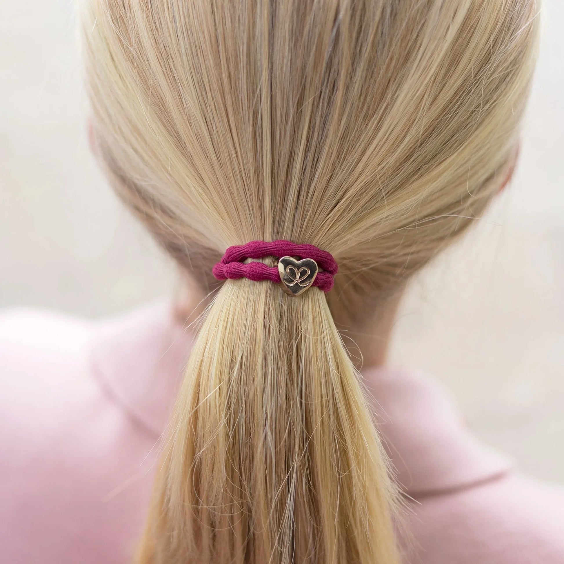 Burgundy red coloured bubble shaped hair tie with gold heart charm model
