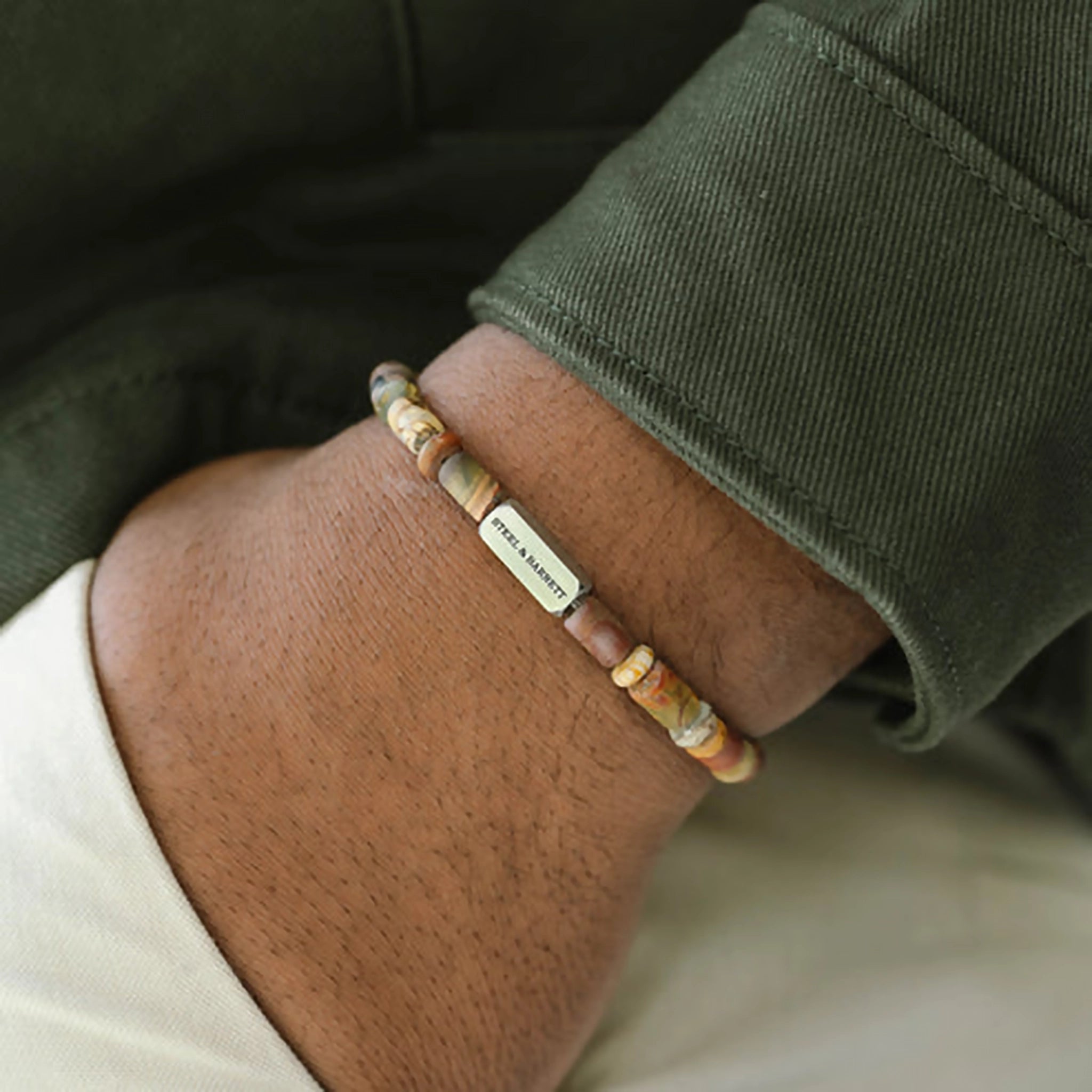 Model wearing a jasper stone bracelet with stainless steel brand detail