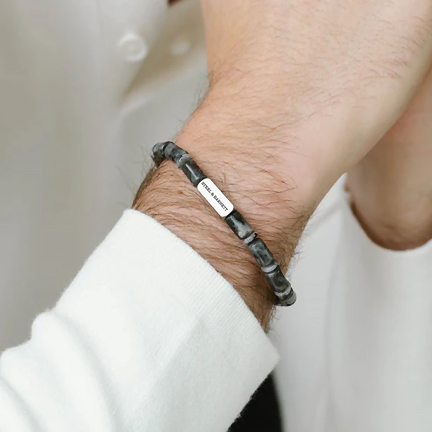 Model wearing a labradorite stone bracelet with stainless steel brand detail
