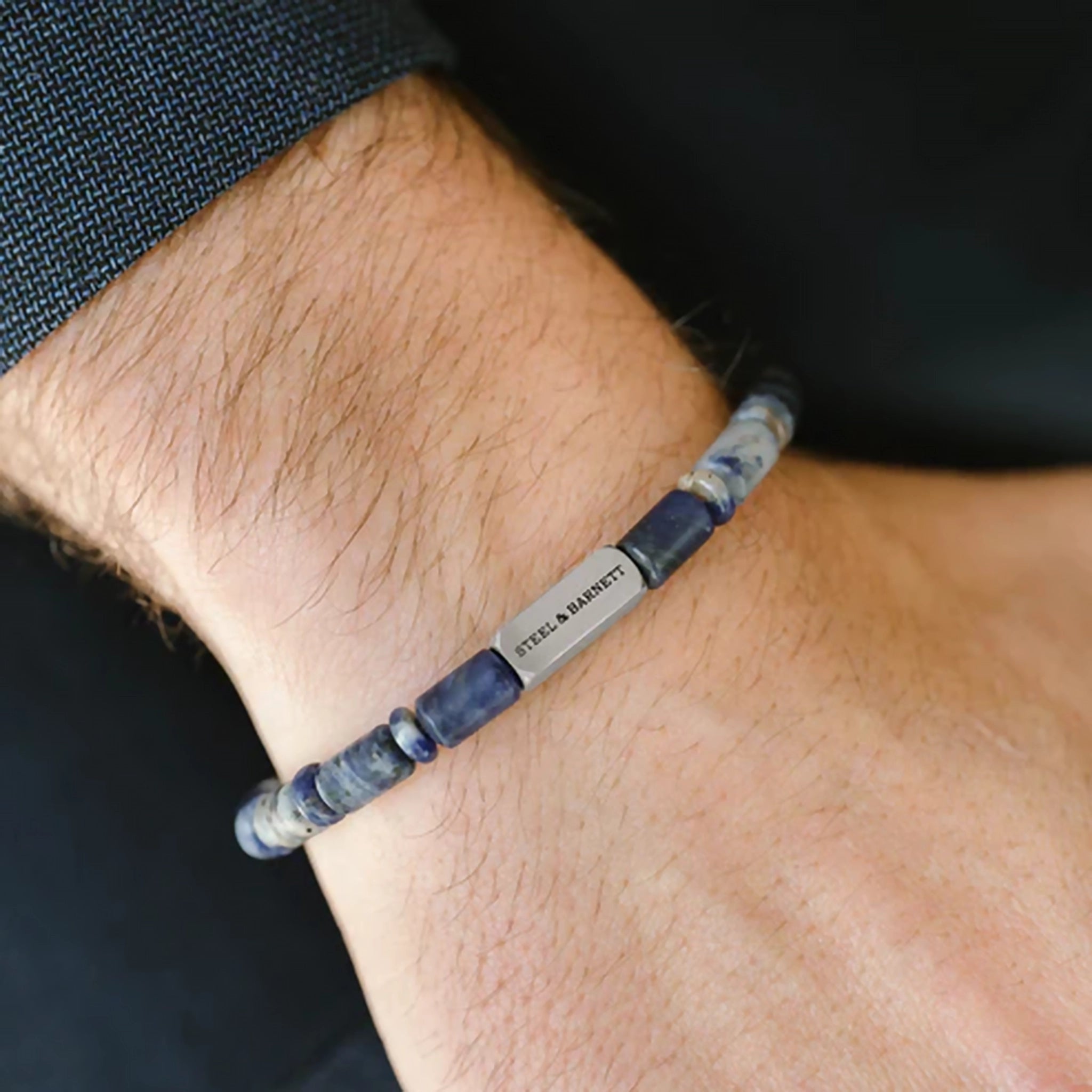 Model wearing a sodalite stone bracelet with stainless steel brand detail