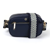 A navy blue camera bag with a blue and cream chevron patterned woven strap