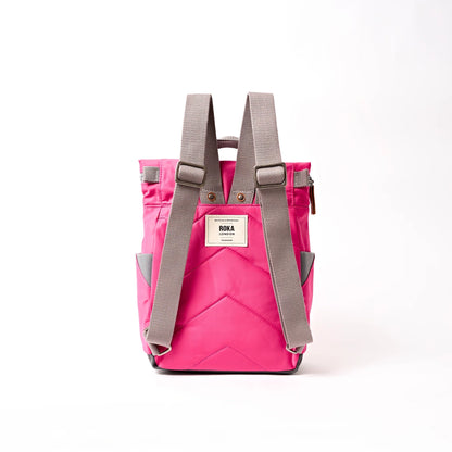 Bright pink hiking roll top backpack with grey shoulder straps