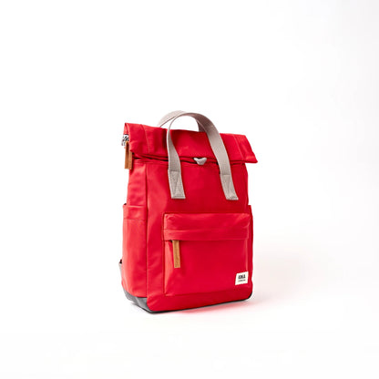 Bright red hiking roll top backpack with grey handle side