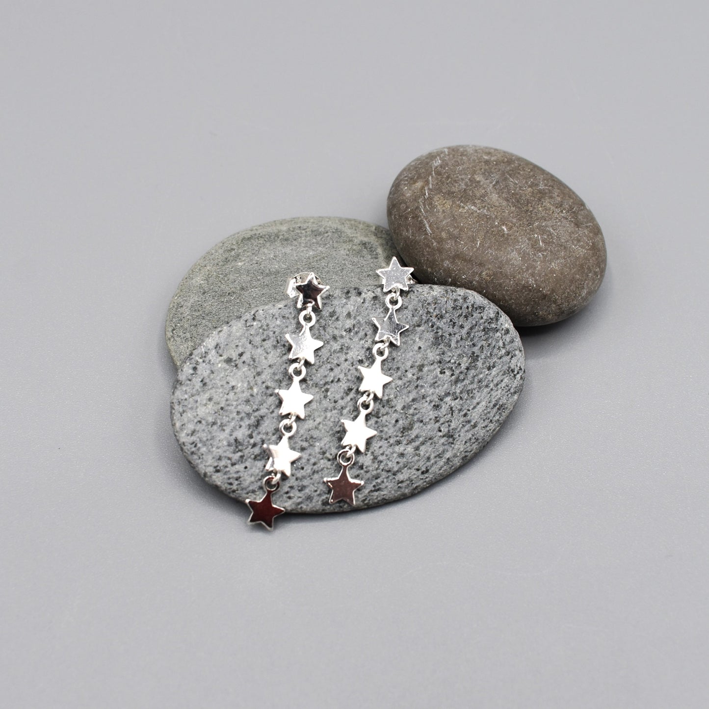 A pair of silver earrings made of linked stars