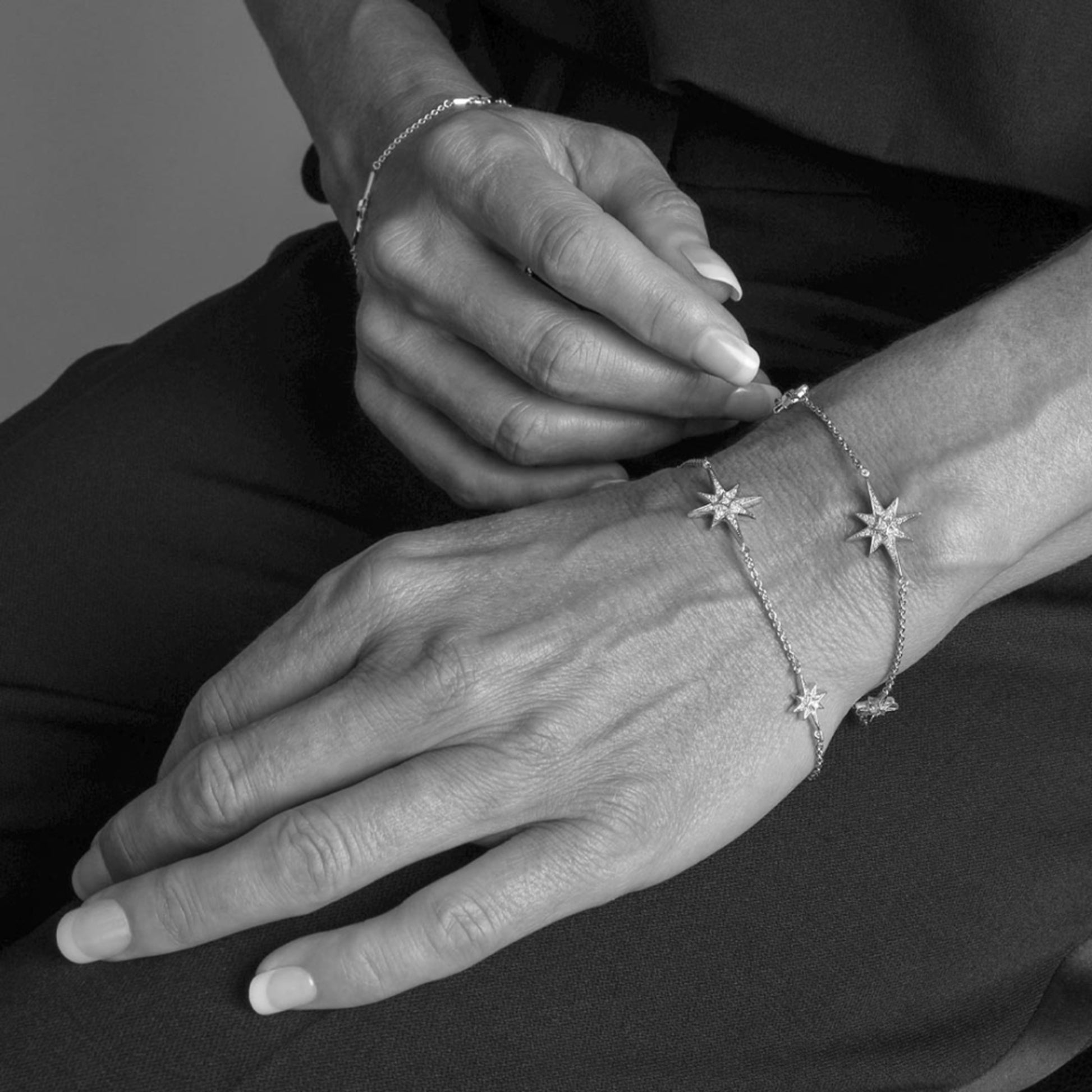 Model wearing a silver North star charm chain bracelet