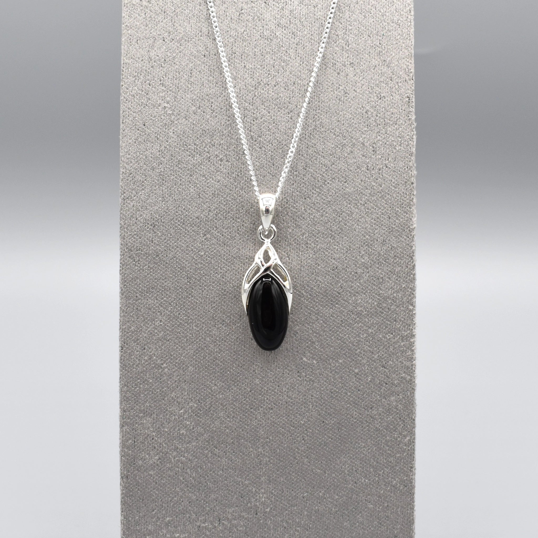 A simple silver Celtic pendant with oval black onyx stone