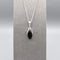 A simple silver Celtic pendant with oval black onyx stone