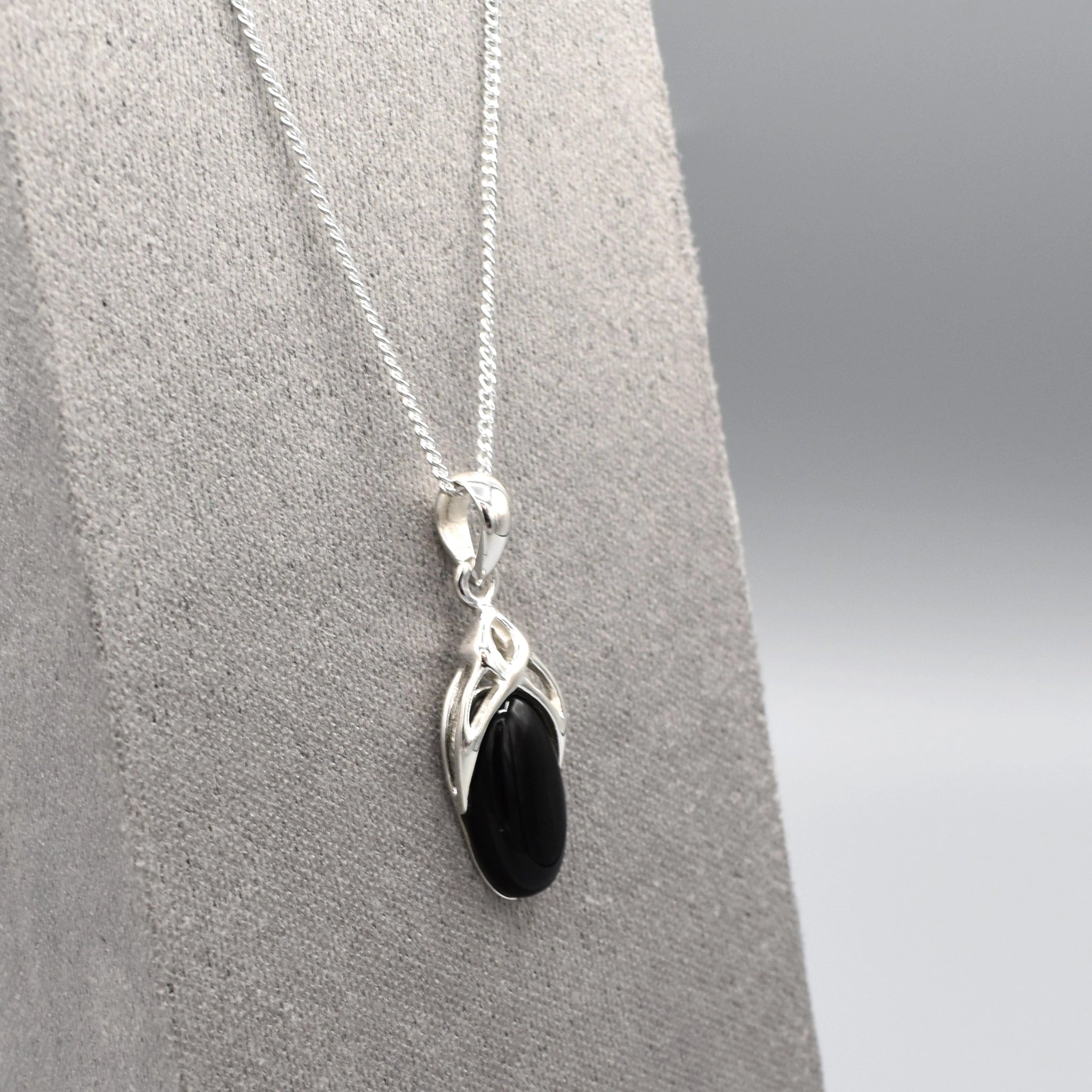 A simple silver Celtic pendant with oval black onyx stone