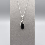 A simple silver Celtic pendant with oval black onyx stone