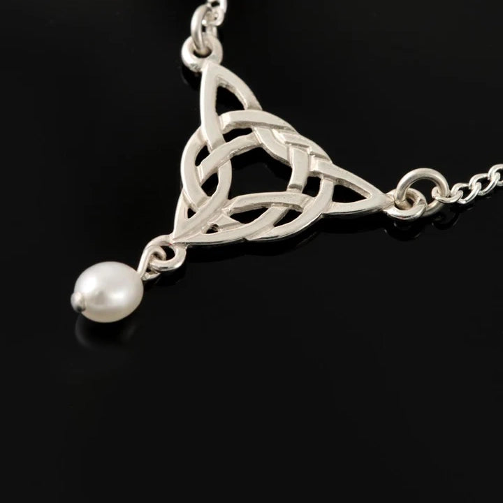 A trinity knot shaped silver necklace with dangling teardrop white pearl