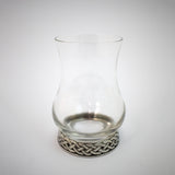 A whisky glass with pewter base engraved with a celtic knot