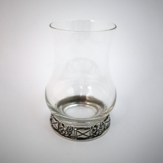 A whisky glass with a pewter base engraved with the Saltire and Lion