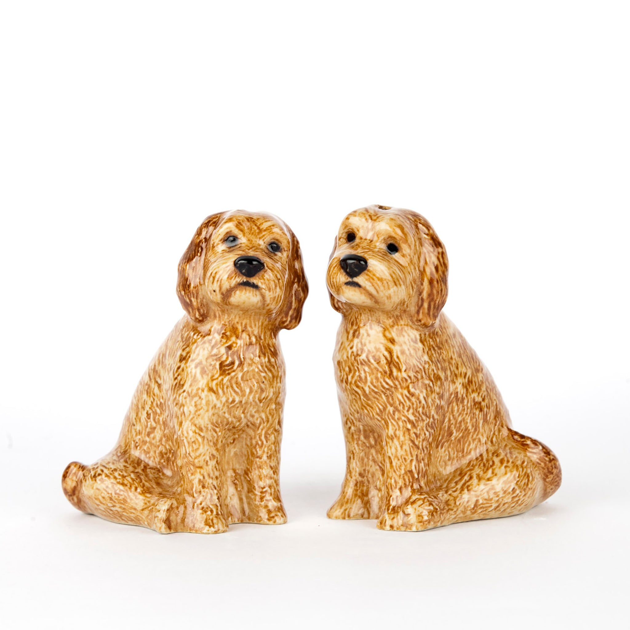 A pair of glazed ceramic salt and pepper shakers shaped like golden cockapoo dogs 