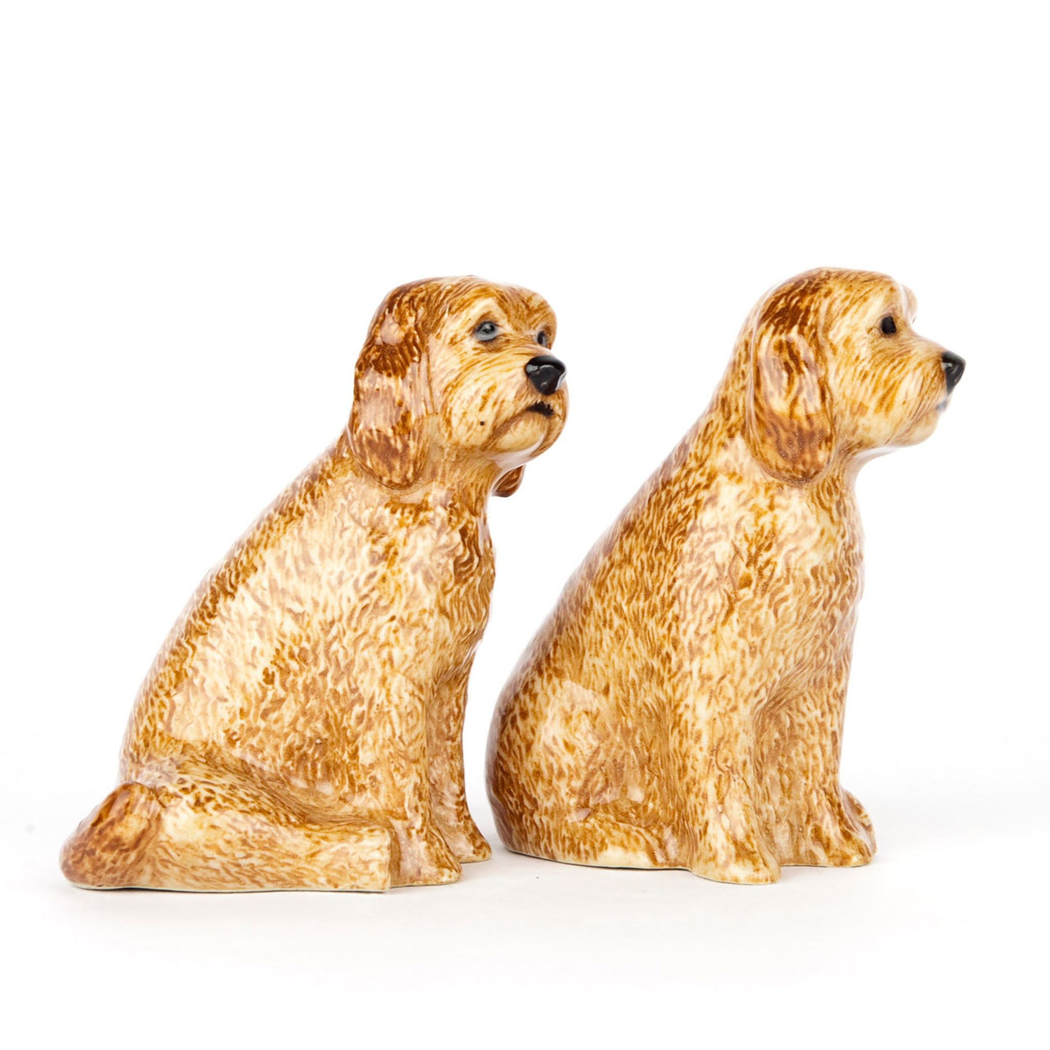 Side view of a pair of glazed ceramic salt and pepper shakers shaped like golden cockapoo dogs
