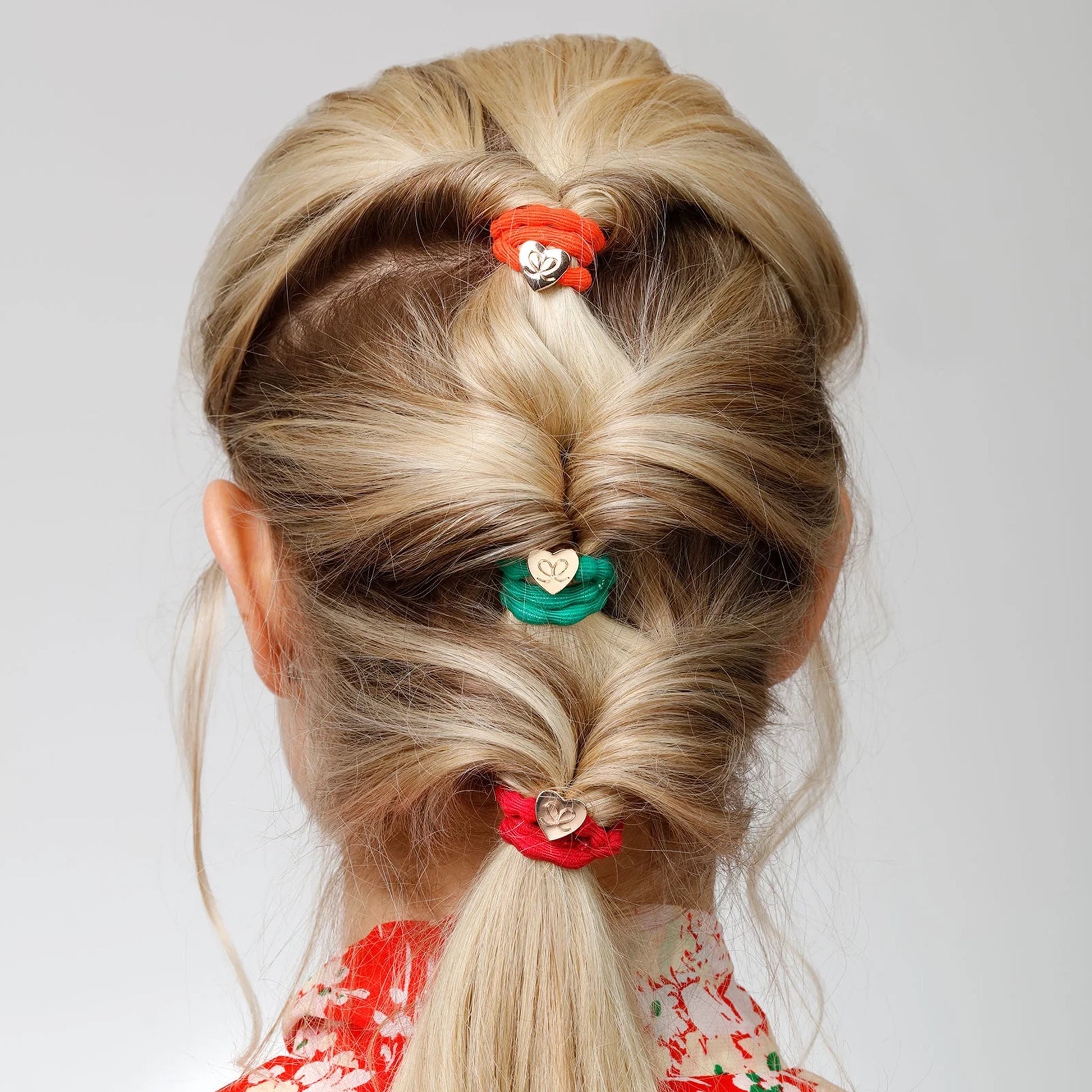 Model wearing bubble shaped hair ties with gold heart charms