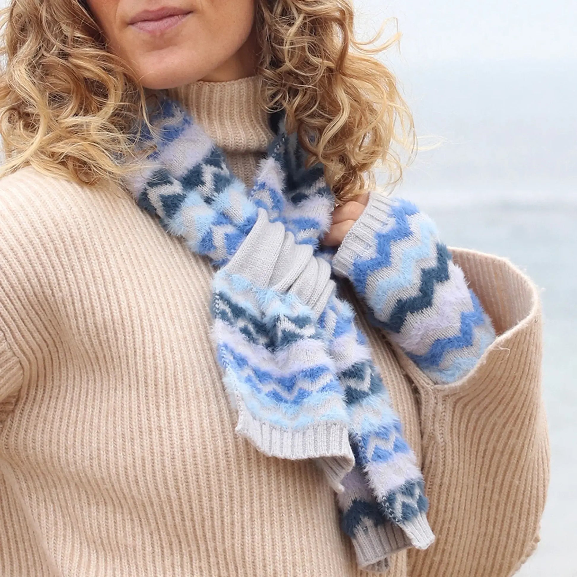 Model wearing a grey pull-through scarf with blue brushed chevron pattern
