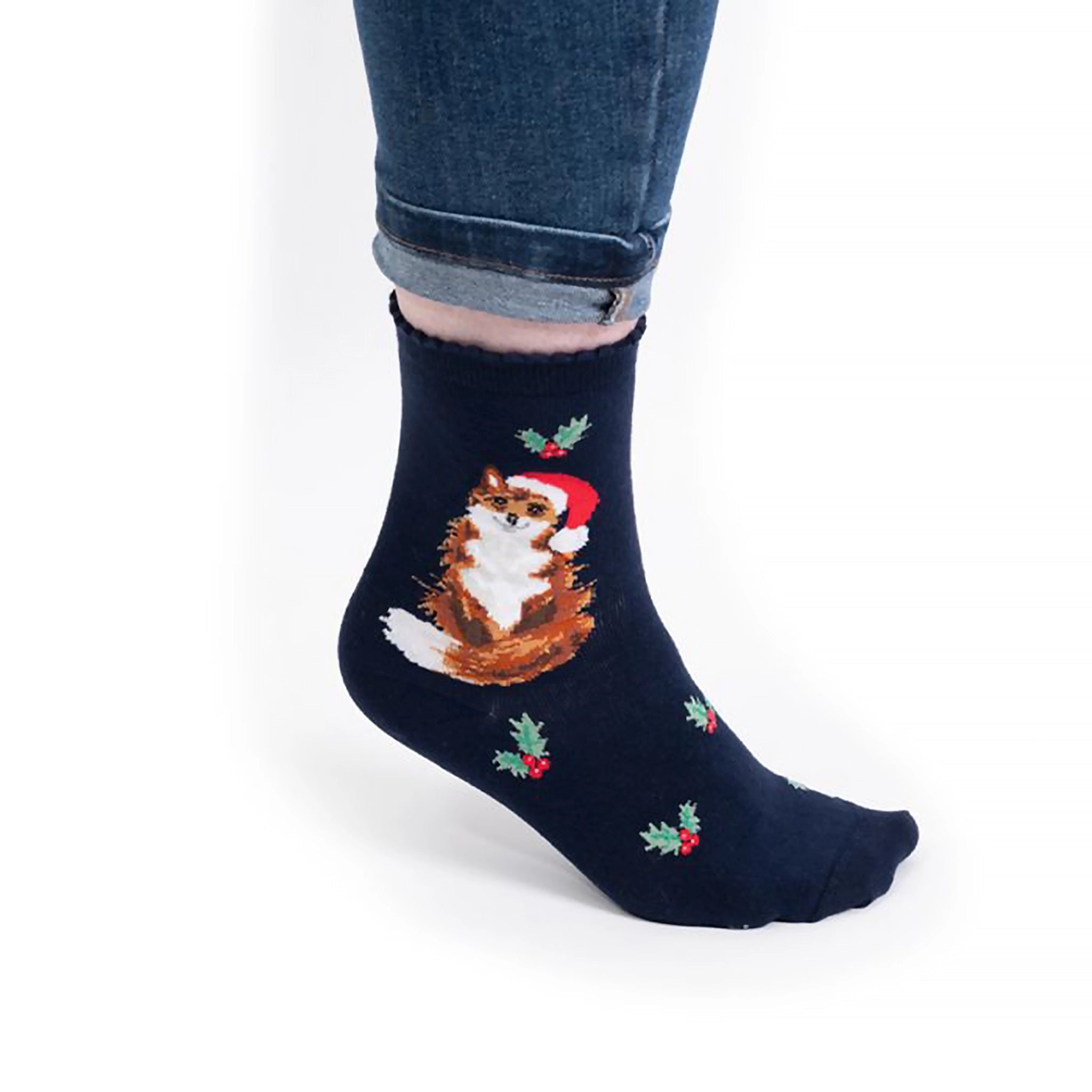 Model wearing pair of Christmas socks in navy with a fox in a Santa hat 