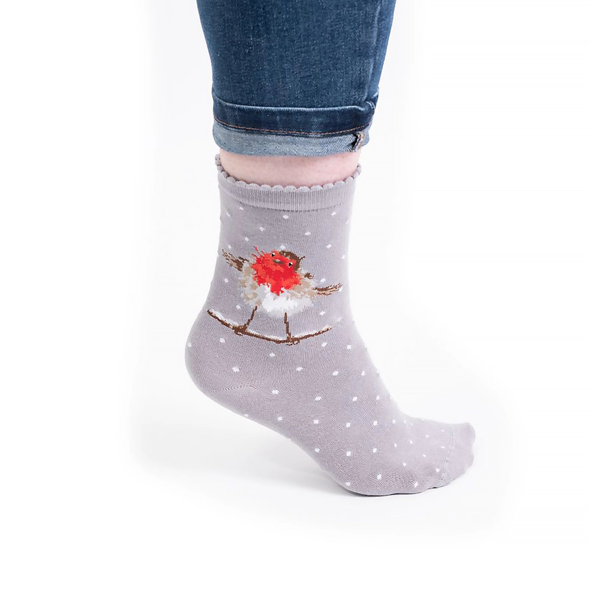 Model wearing pair of Christmas socks in grey with a robin and polka dots