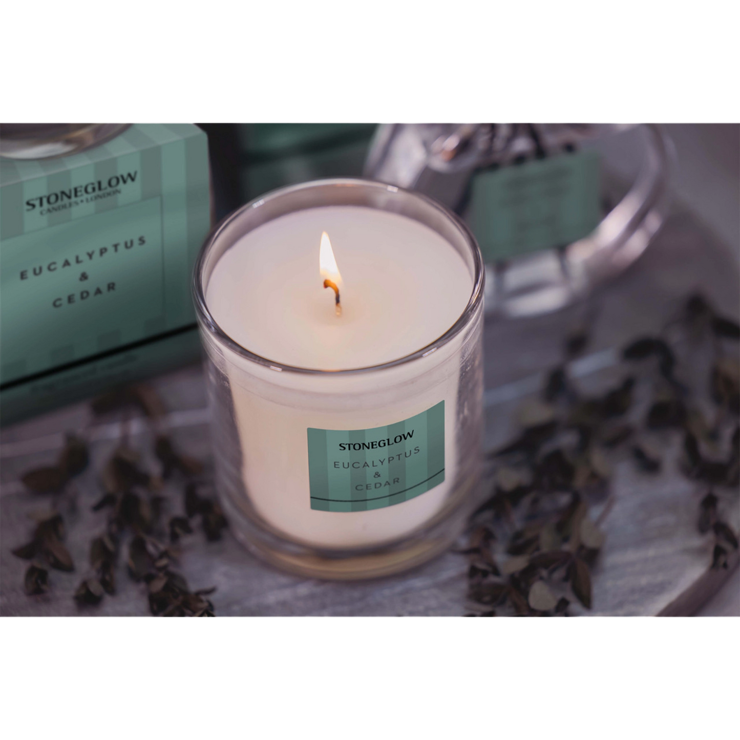 Stoneglow Eucalyprus & Cedar tumbler candle with green striped packaging lifestyle