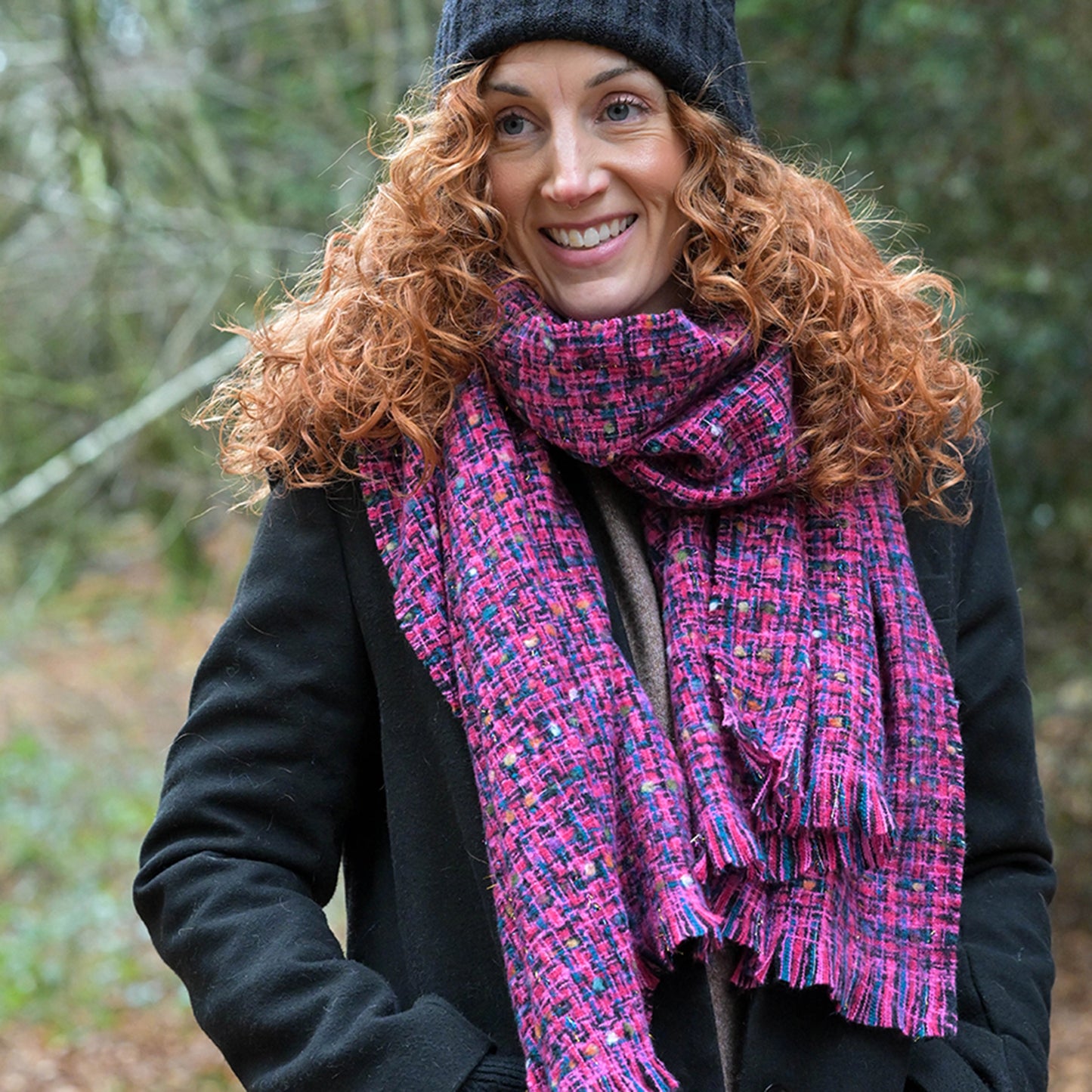 Model wearing pink and blue chunky woven knit scarf