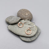 A pair of silver hook earrings with an irregular rose gold plated circle drop