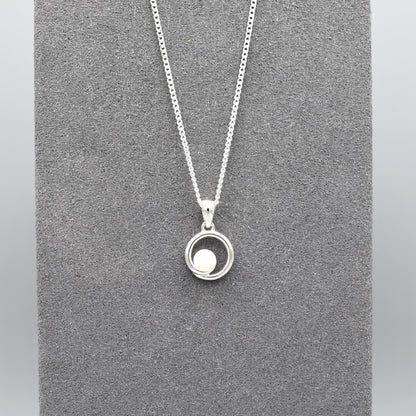 A round swirl pendant with a white pearl