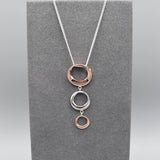 Pendant with three graduated irregular shaped circle drops in rose gold and silver