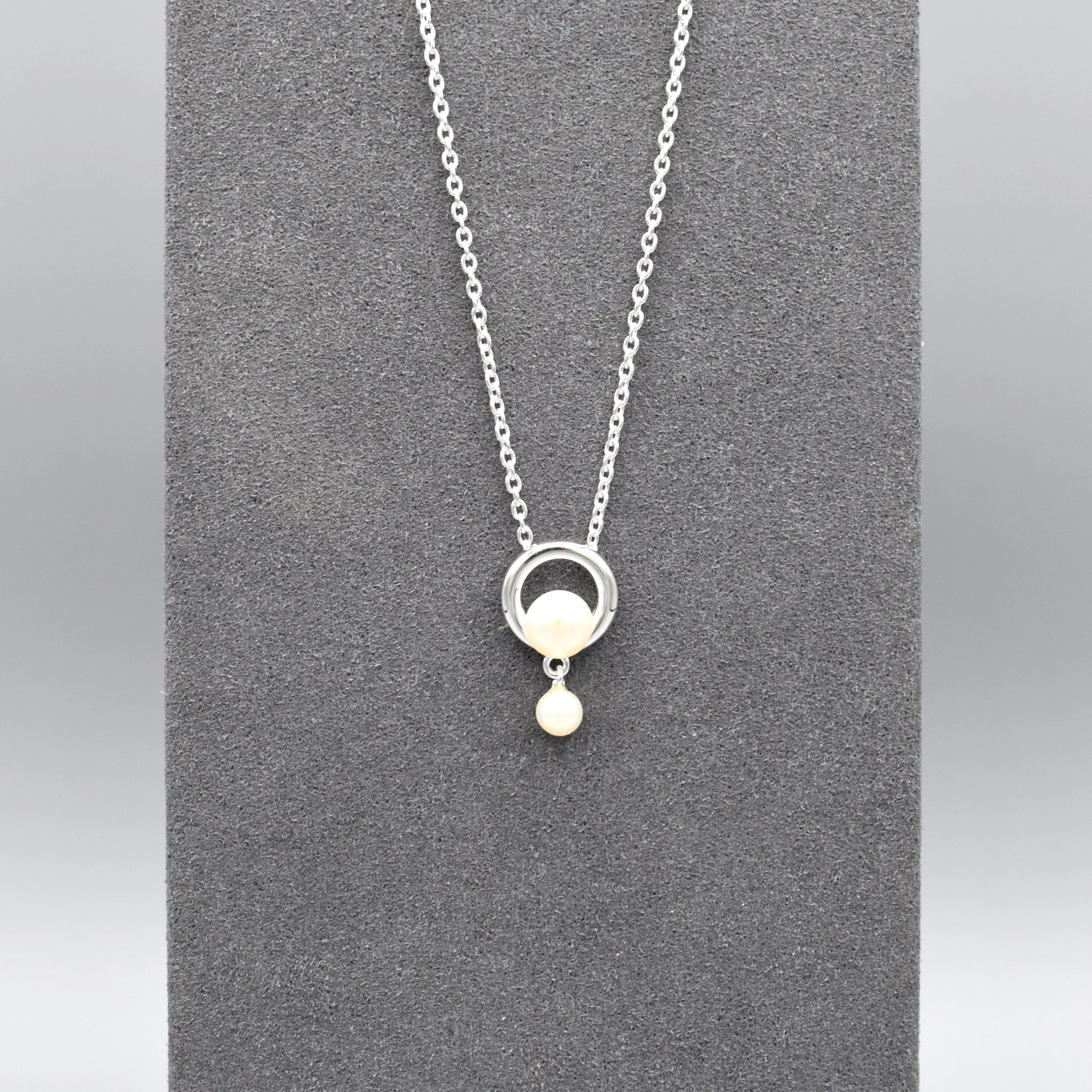 Pendant with a simple circle set with a pearl and a smaller drop pearl at the bottom