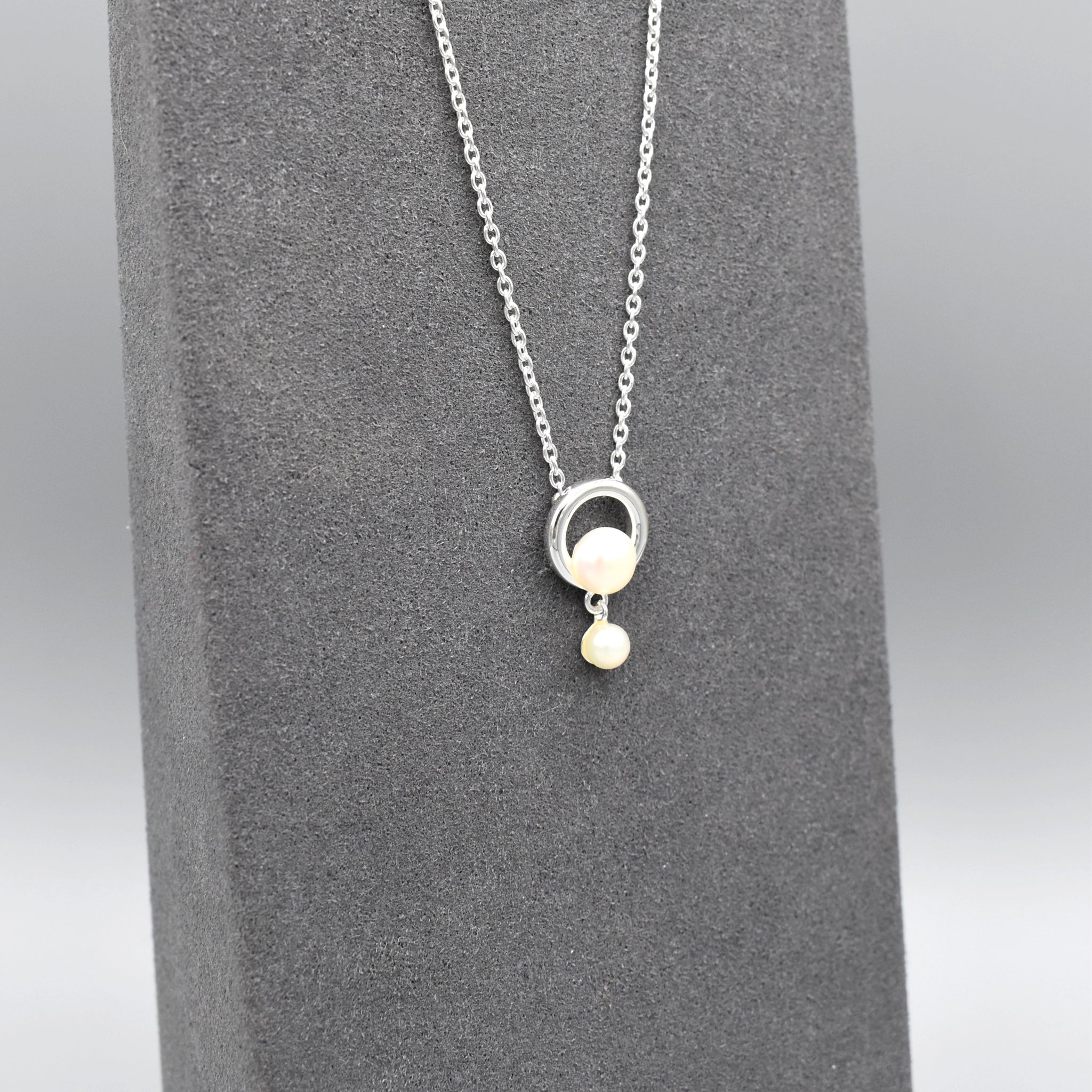 Pendant with a simple circle set with a pearl and a smaller drop pearl at the bottom