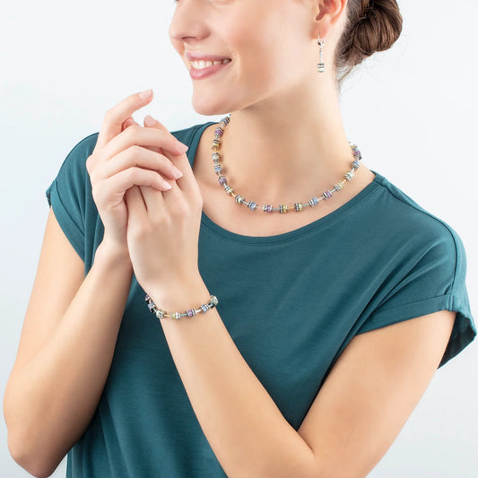 Model wearing a steel bracelet featuring multicolour pastel stones