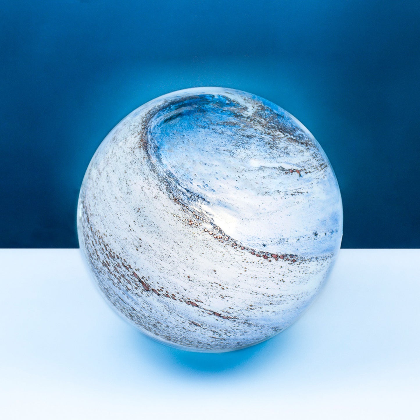 A glass orb light with swirling copper and blue colours
