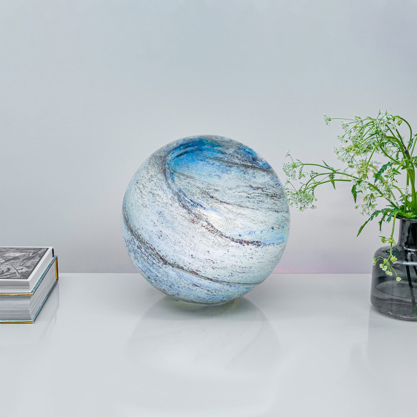 A glass orb light with swirling copper and blue colours lifestyle