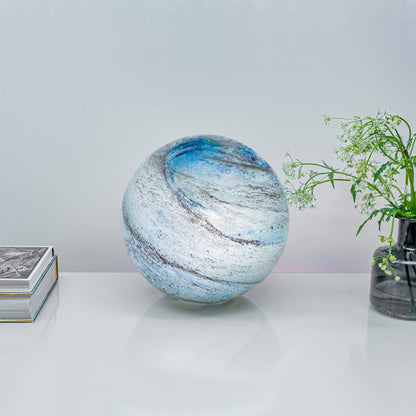 A glass orb light with swirling copper and blue colours lifestyle