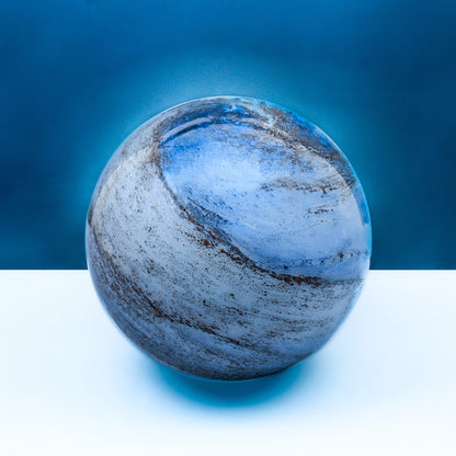 A glass orb light with swirling copper and blue colours off