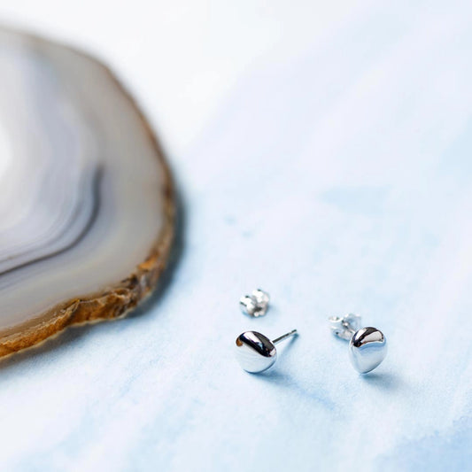 A pair of teardrop pebble shaped silver stud earrings with butterfly fittings