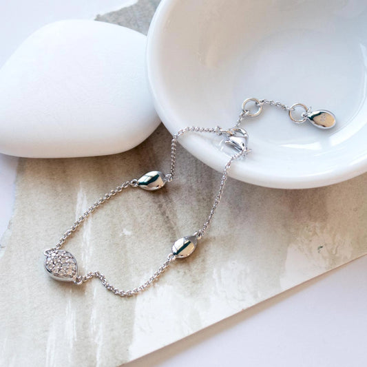 A silver bracelet with three pebble shaped pendants and one with CZ stones lifestyle