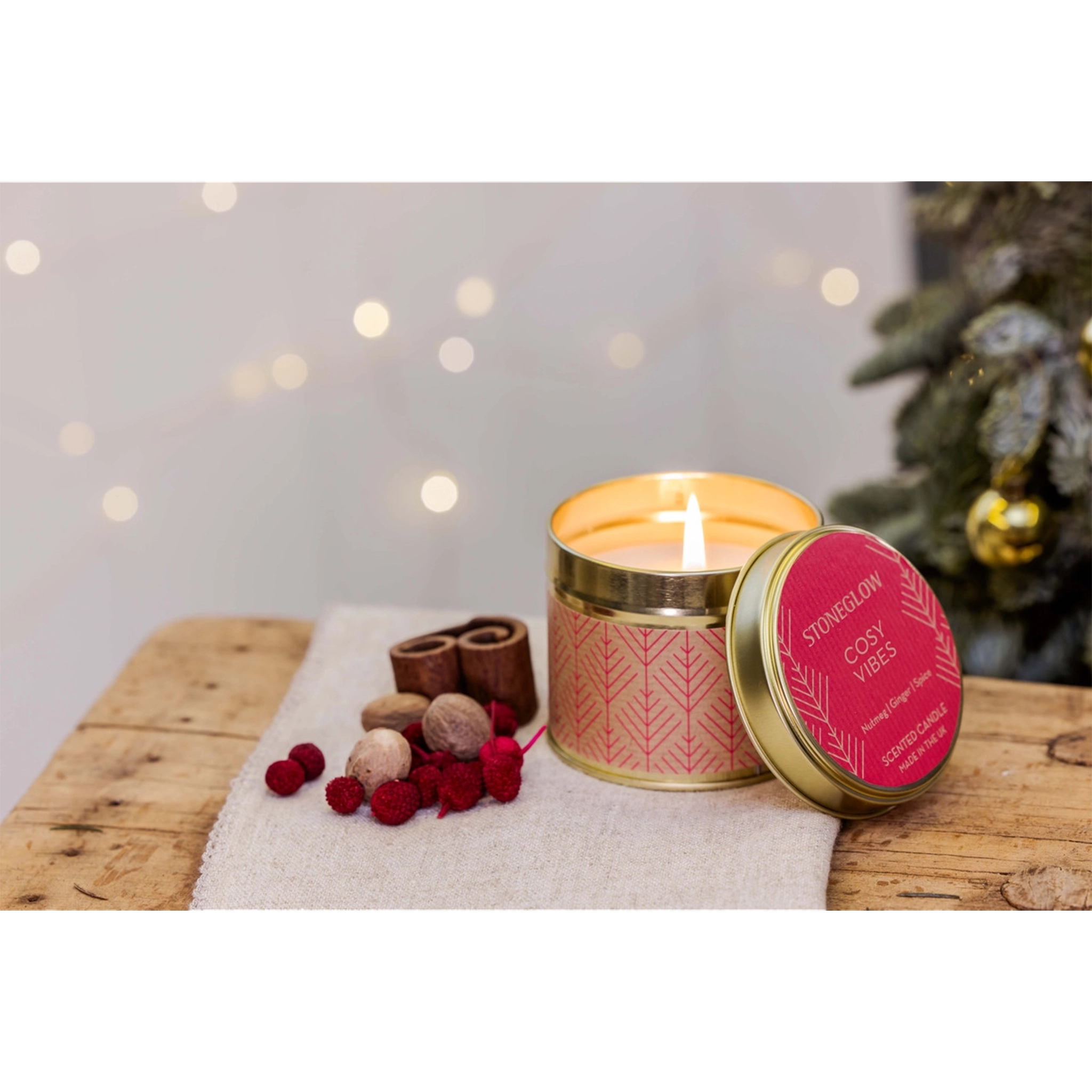 A gold coloured candle tin with red Scandi style pattern in the scent 'Cosy Vibes' lifestyle image