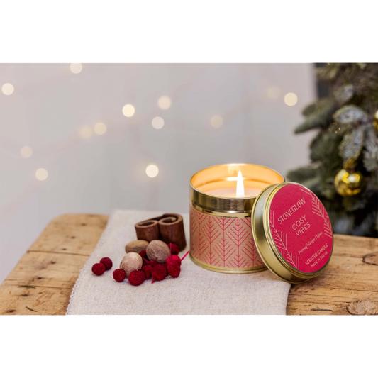 A gold coloured candle tin with red Scandi style pattern in the scent 'Cosy Vibes' lifestyle image