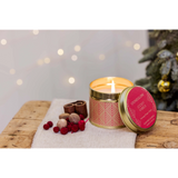 A gold coloured candle tin with red Scandi style pattern in the scent 'Cosy Vibes' lifestyle image