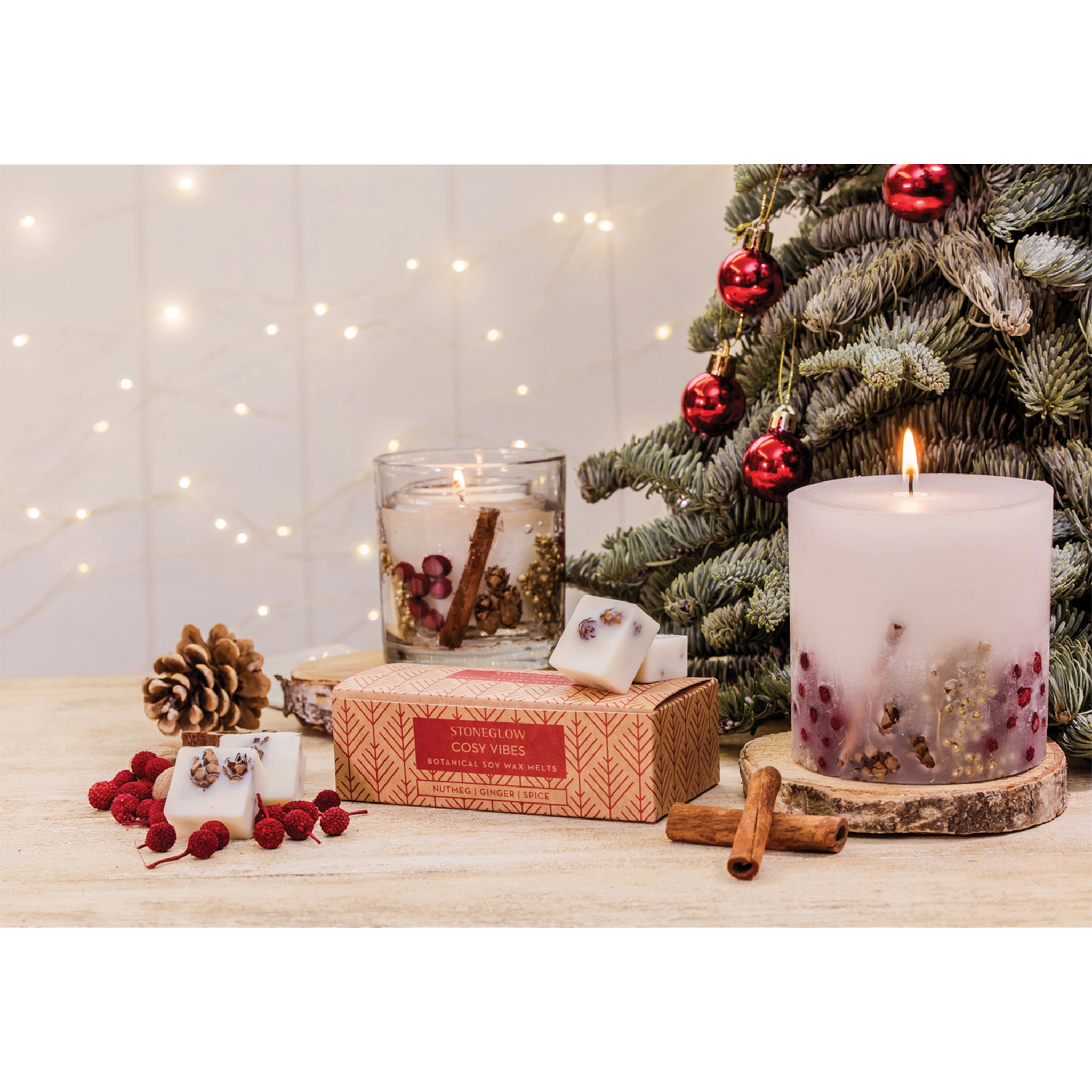 A tumbler candle with seasonal berries and pinecones in a clear gel lifestyle image