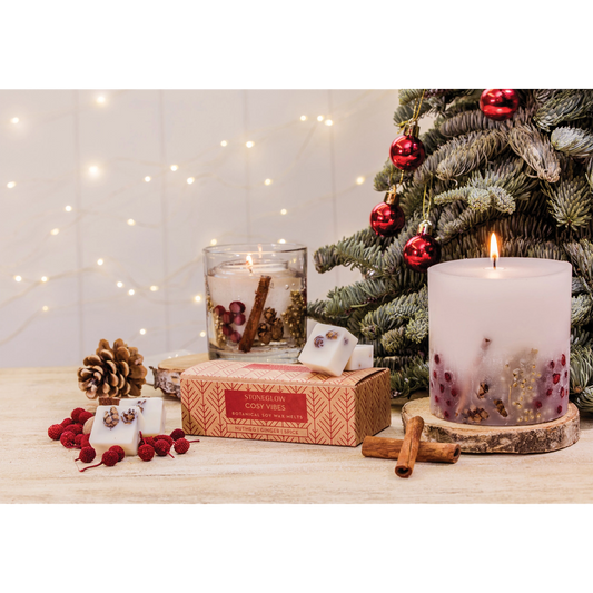 A tumbler candle with seasonal berries and pinecones in a clear gel lifestyle image