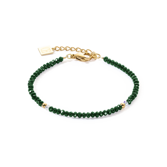 A gold bracelet with cut dark green glass beads