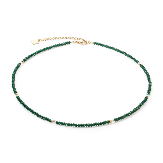 A gold necklace with cut dark green glass beads
