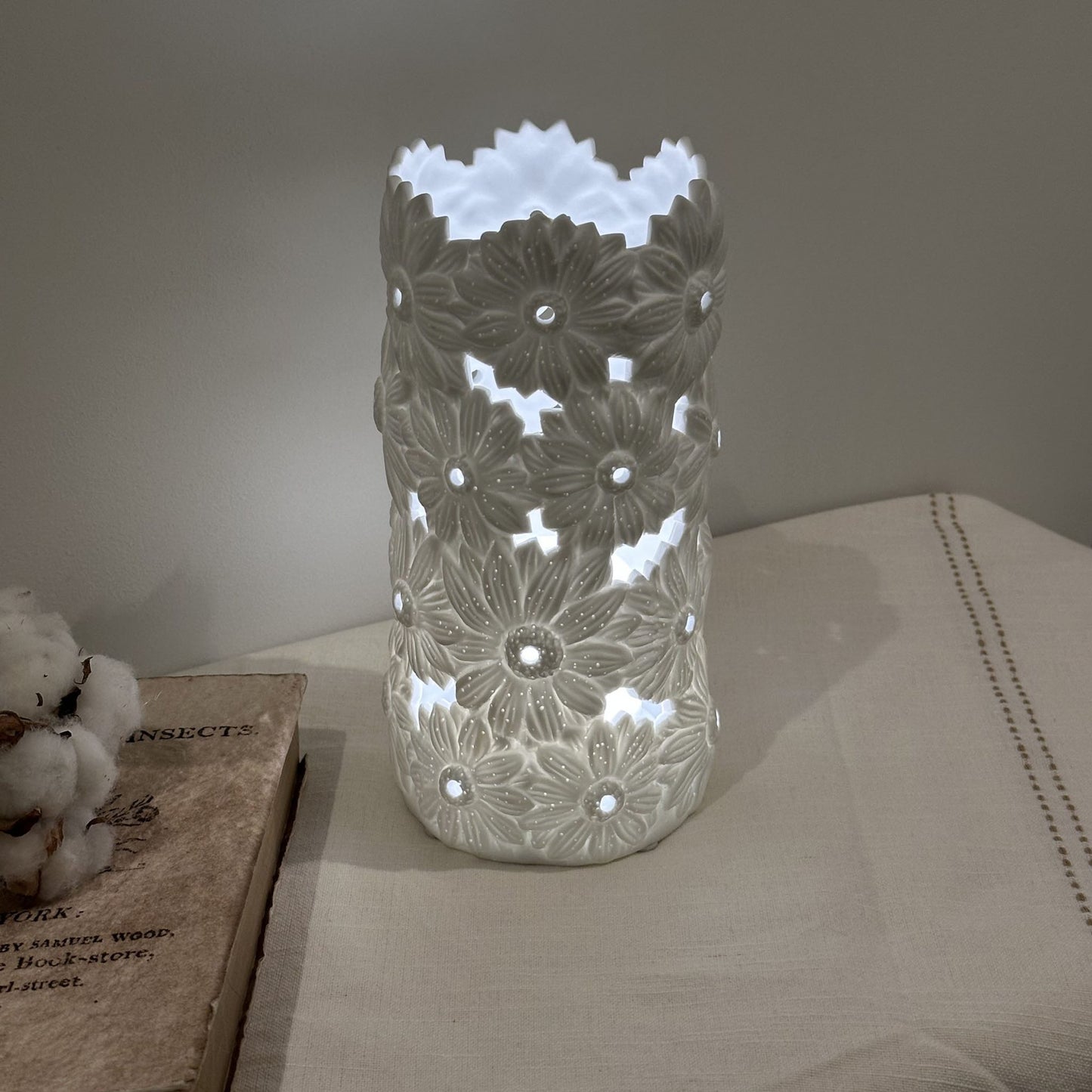 A porcelain lamp with 3D effect daisy flower design lit up